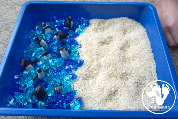 Penguin Rice Sensory Bin - with penguins, blue acrylic rocks and rice for a fun polar animal sensory bin that kids can play in. - 3Dinosaurs.com