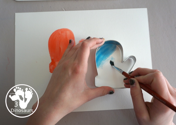 Mitten Watercolor Painting With Cookie Cutters - A simple painting you can do with kids of different ages by painting inside a cookie cutter to make a fun mitten painting - 3Dinosaurs.com