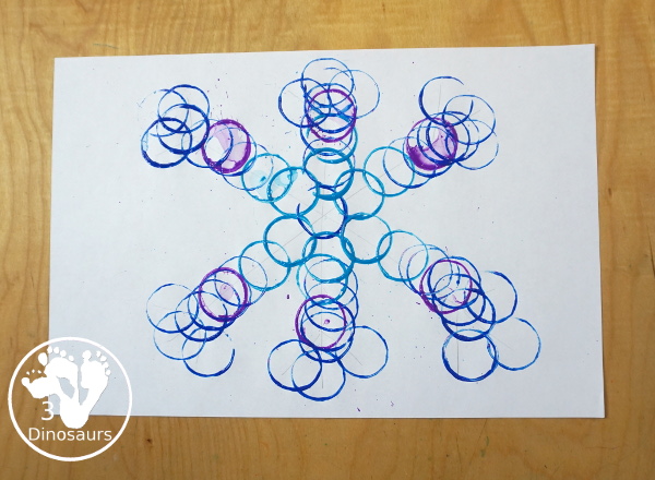Paper Roll Painted Snowflake - a fun snowflake painting with blue and purple colors and using paper rolls to make the snowflakes. A simple and easy PreK and kindergarten craft for winter. - 3Dinosaurs.com