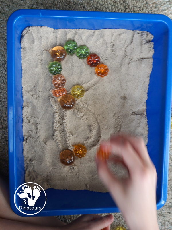 Pumpkin & Kinetic Sand Sensory Bin - a simple and easy fall sensory bin with pumpkins and kinetic sand for kids to play in. - 3Dinosaurs.com