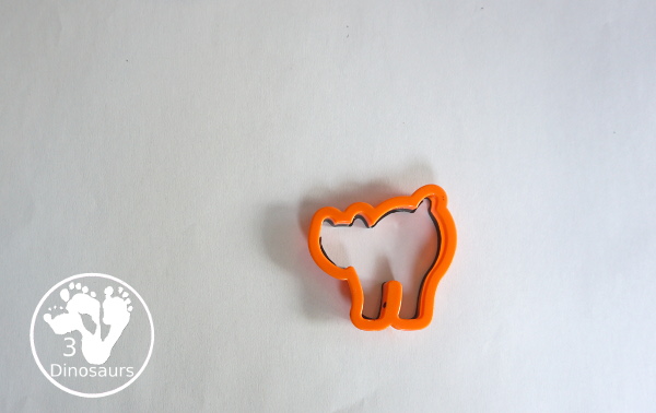 Halloween Stamping With Cookie Cutters - painting with cookie cutters using them to stamp paint with the cookie cutters on a piece of paper. A great tot, preschool and prek painting activity - 3Dinosaurs.com