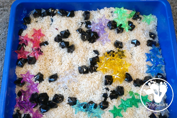 Star Sensory Bin For a Space Theme for kids in preschool, prek and kindergarten. A fun and easy to set up sensory bin with stars, black rocks and rice for base for a space theme - 3Dinosaurs.com