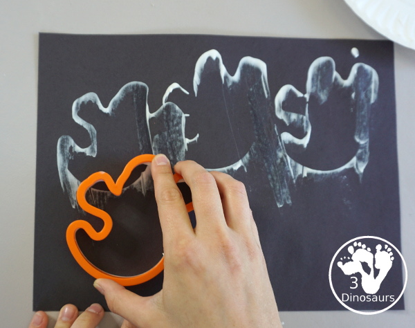 Ghost Scrape Painting with Cookie Cutters - a simple painting activity for kids with paint and ghost cookie cutters that different ages can make together for Halloween. - 3Dinosaurs.com