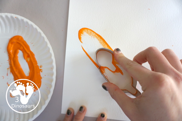 Turkey Feather Scrap Painting for Kids - a fun turkey craft made with a cookie cutter feather and construction paper. A fun painting idea with feathers for a Thanksgiving craft for kids in preschool, prek, and kindergarten. 3Dinosaurs.com