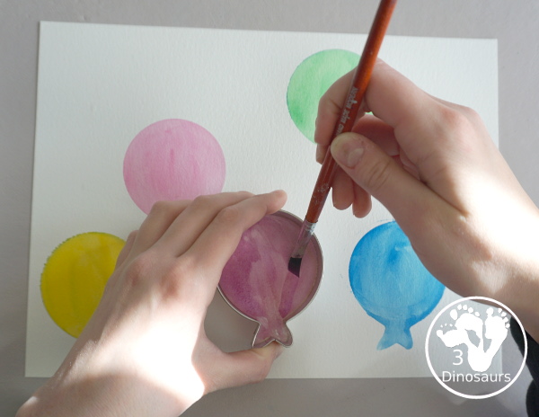 Balloon Watercolor Painting with Cookie Cutters - a simple watercolor painting with a balloon cookie cutter that kids of all ages can do for a party or New Year's Eve - 3Dinosaurs.com