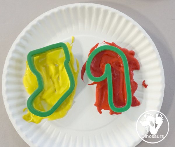 Christmas Cookie Cutter Painting - You stamp cookie cutters on the paper with each cookie cutter having a different color - 3Dinosaurs.com