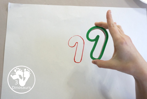 Christmas Cookie Cutter Painting - You stamp cookie cutters on the paper with each cookie cutter having a different color - 3Dinosaurs.com