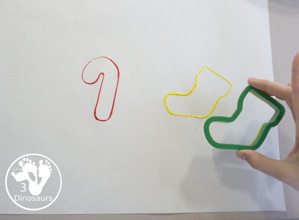 Christmas Cookie Cutter Painting - You stamp cookie cutters on the paper with each cookie cutter having a different color - 3Dinosaurs.com