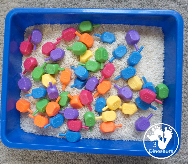 Dreidel Sensory Bin with Rice for Hanukkah - A simple Hanukkah sensory bin with dreidels and rice for the sensory bin - 3Dinosaurs.com