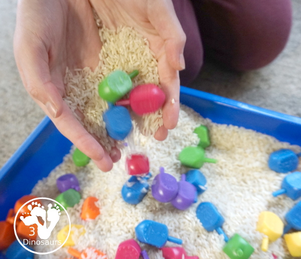 Dreidel Sensory Bin with Rice for Hanukkah - A simple Hanukkah sensory bin with dreidels and rice for the sensory bin - 3Dinosaurs.com