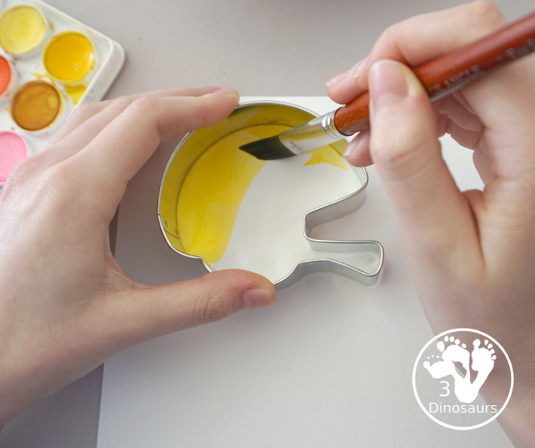 Football Cookie Cutter Watercolor Painting - a fun painting that kids can do with a football theme. A great way to do a fun watercolor painting is by different football team colors. - 3Dinosaurs.com