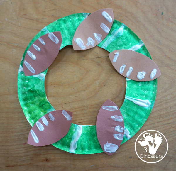 Football Wreath Craft For Kids - a fun wreath craft for a football theme. You have a green wreath with white lines and footballs around the wreath. Great for any football theme. - 3Dinosaurs.com