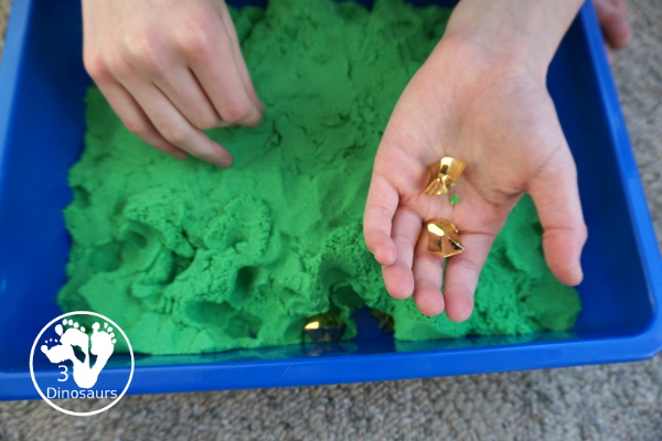 St. Patrick's Day Gold Find Sensory Bin - a fun kinetic sand sensory bin for St. Patrick's Day with finding the gold in the sensory bin - 3Dinosaurs.com