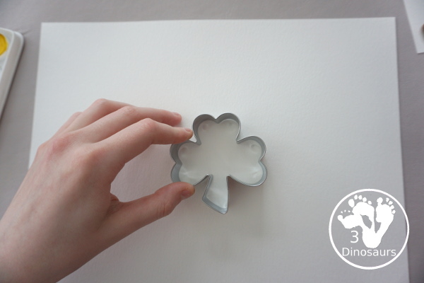 Clover Watercolor Painting for kids - You use watercolor paints, watercolor paper, and clover cookie cutters to make a fun Saint Patrick's Day watercolor painting - 3Dinosaurs.com