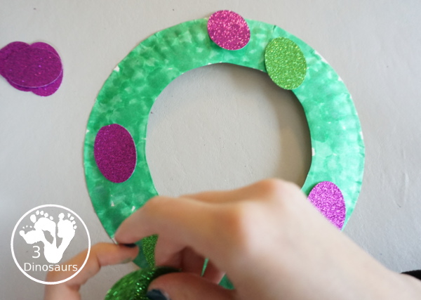 Glitter Easter Egg Wreath Craft - a fun Easter Egg wreath made with a paper plate and ovals for the eggs - 3Dinosaurs.com