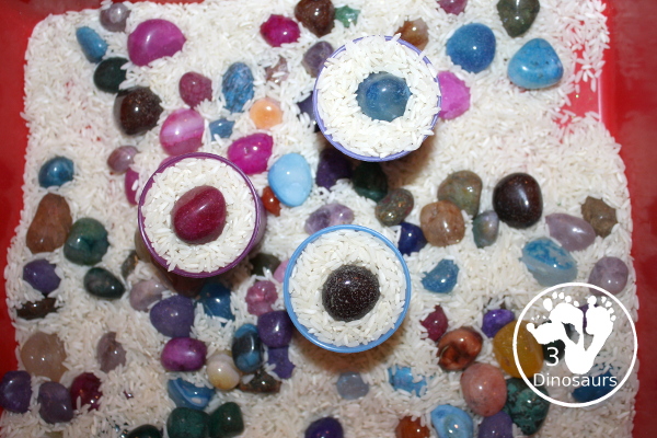 Rock & Rice Sensory Bin - filling up cups with rice and putting a rock on top. - 3Dinosaurs.com