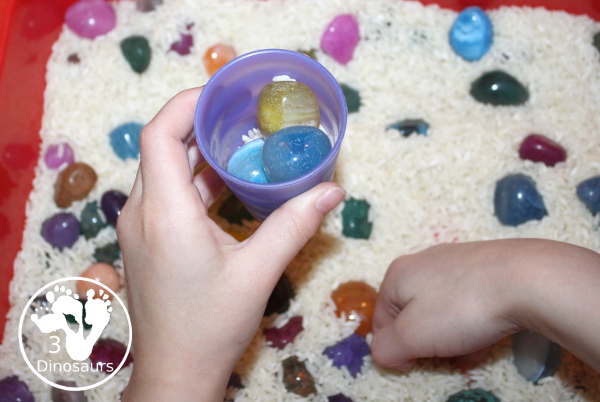Rock & Rice Sensory Bin - filling up cups with rocks and pouring rice in to fill the space. - 3Dinosaurs.com
