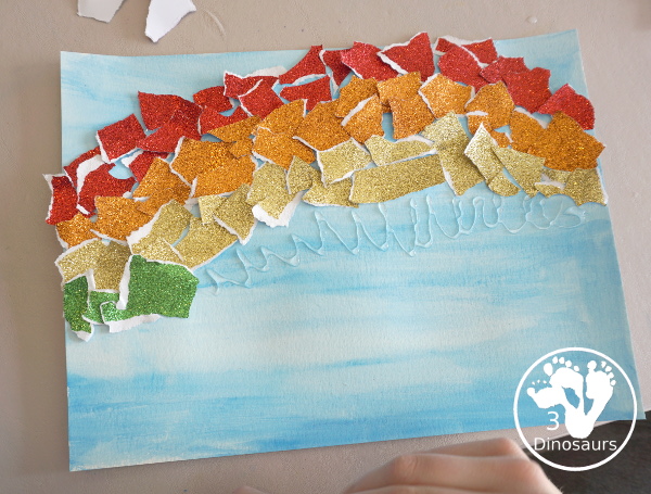 Torn Paper Glitter Rainbow with watercolor Sky Craft - a simple rainbow you can make with torn glitter paper and painting a watercolor background. A simple rainbow for kids prek to first grade - 3Dinosaurs.com