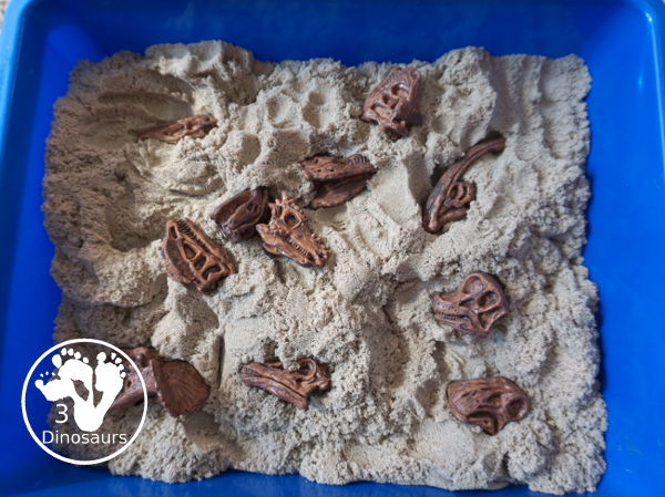 Dinosaur and Kinetic Sand Sensory Bin - a simple sensory bin put together to play with dinosaur bones and kinetic sand. Super simple to set up and use for sensory play.- 3Dinosaurs.com
