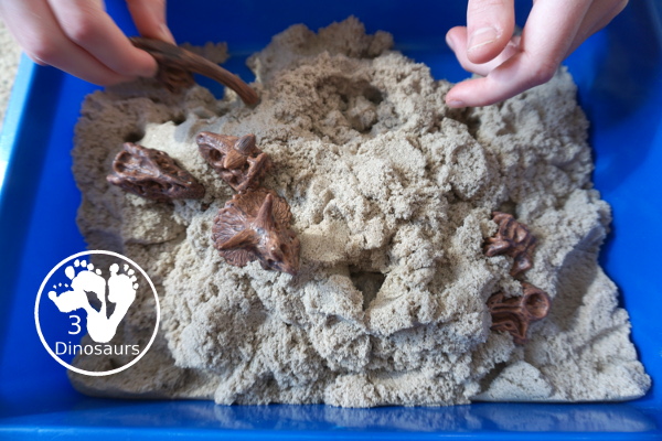 Dinosaur and Kinetic Sand Sensory Bin - a simple sensory bin put together to play with dinosaur bones and kinetic sand. Super simple to set up and use for sensory play.- 3Dinosaurs.com