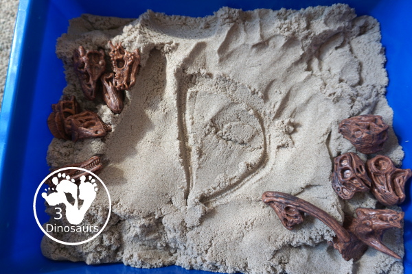 Dinosaur and Kinetic Sand Sensory Bin - a simple sensory bin put together to play with dinosaur bones and kinetic sand. Super simple to set up and use for sensory play.- 3Dinosaurs.com