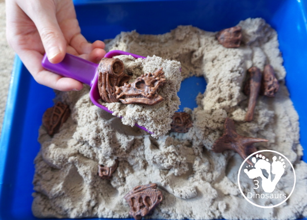 Dinosaur and Kinetic Sand Sensory Bin - a simple sensory bin put together to play with dinosaur bones and kinetic sand. Super simple to set up and use for sensory play.- 3Dinosaurs.com