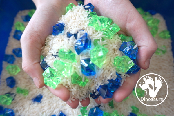 Blue and Green Sensory Bin For Earth Day - scoop up the sensory bin in hands - 3Dinosaurs.com