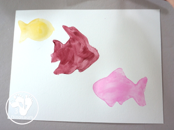Fish Watercolor Painting with Cookie Cutters is an easy ocean fish painting you can do with kids. You can use one cookie cutter or several fish cookie cutters to make  the painting  - 3Dinosaurs.com