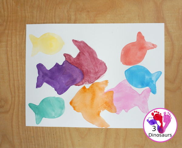 Fish Watercolor Painting with Cookie Cutters is an easy ocean fish painting you can do with kids. You can use one cookie cutter or several fish cookie cutters to make  the painting  - 3Dinosaurs.com