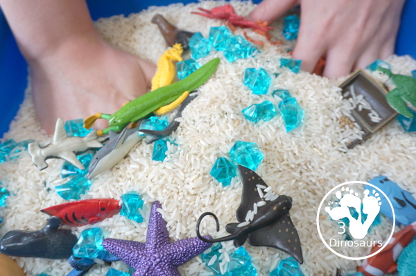 Ocean Rice and Rock Sensory Bin - a simple rice base sensory bin that has ocean animals and blue acrylic rocks in the bin. A simple sensory bin for any ocean theme - 3Dinosaurs.com