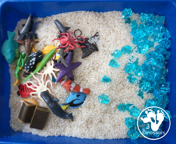 Ocean Rice and Rock Sensory Bin - a simple rice base sensory bin that has ocean animals and blue acrylic rocks in the bin. A simple sensory bin for any ocean theme - 3Dinosaurs.com