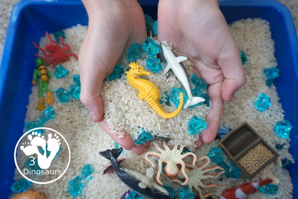 Ocean Rice and Rock Sensory Bin - a simple rice base sensory bin that has ocean animals and blue acrylic rocks in the bin. A simple sensory bin for any ocean theme - 3Dinosaurs.com
