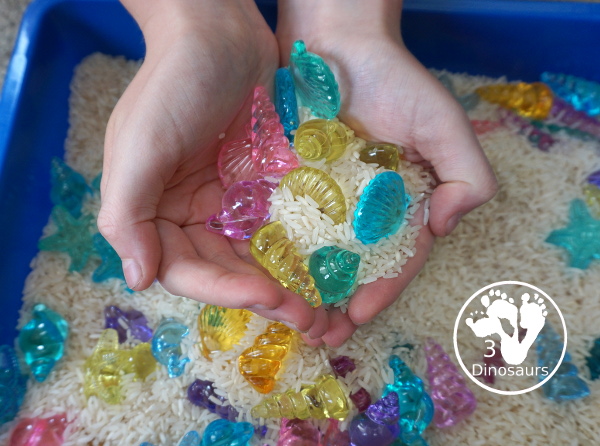 Shell and Rice Sensory Bin has a rice filler with acrylic sheets in different colors as the part in the sensory bin. This is a simple beach sensory bin idea for kids. - 3Dinosaurs.com