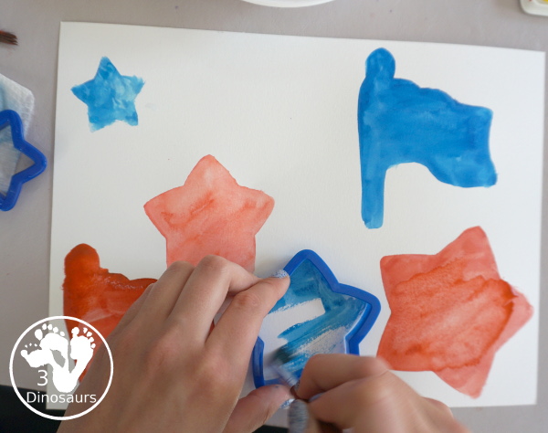 Stars & Flag Watercolor Painting with Cookie Cutters - a simple painting activity that you can do with kids with red and blue colors painting inside stars and flags.- 3Dinosaurs.com