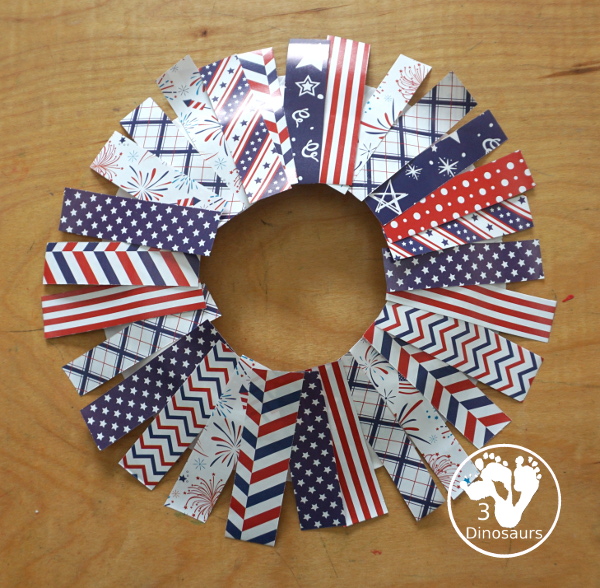 Red White and Blue Wreath Craft - a fun wreath craft made with scrapbook or any type Fourth of July paper with the red and blue themed paper around the paper plate. A simple craft you can do with preschool, prek and kindergarten age kids. - 3Dinosaurs.com