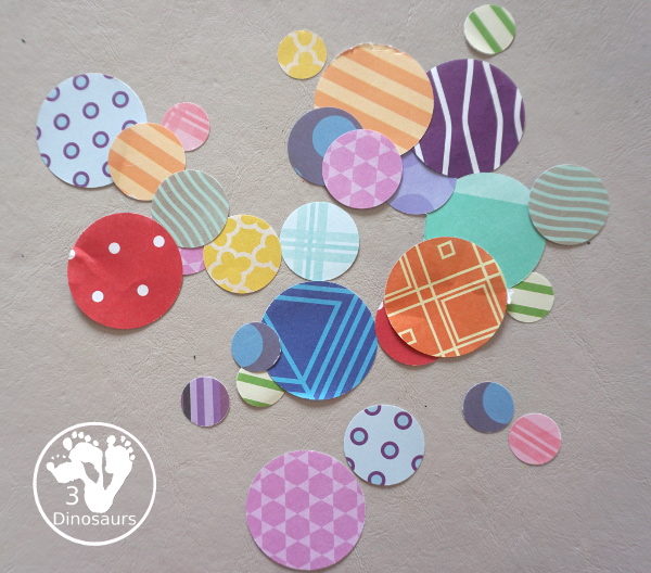 Scrapbook Paper Space Wreath Craft - a fun space craft for kids that is made with a paper plate, craft punches that are circles and stars with glitter paper and scrapbook paper. It makes a fun space craft. - 3Dinosaurs.com