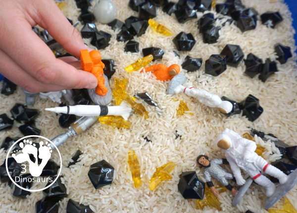 Space Sensory Bin With Rice and Rocks - you have space figures, yellow stars, and rice for this simple sensory b8in. This is great for a space theme with kids. And they will enjoy exploring space themes in the sensory bin. A fun sensory bin for kids in preschool, prek and kindergarten. - 3Dinosaurs.com